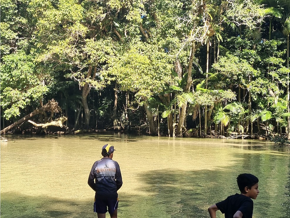 Two young people standing in a forest waterway in Far North Queensland.